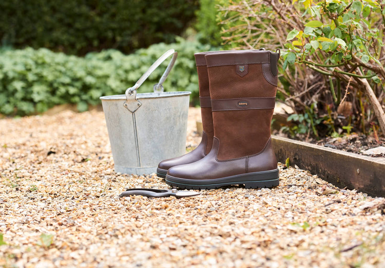 Pair of Dubarry Womens Kildare calf height leather Country Boot, walnut brown colour sitting out in an outdoor setting.