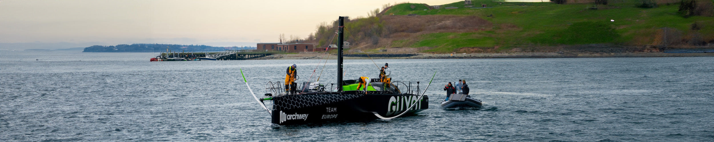 Wide image of the Team Guyot boat being brought in to port after losing their rig at the end of Leg 4